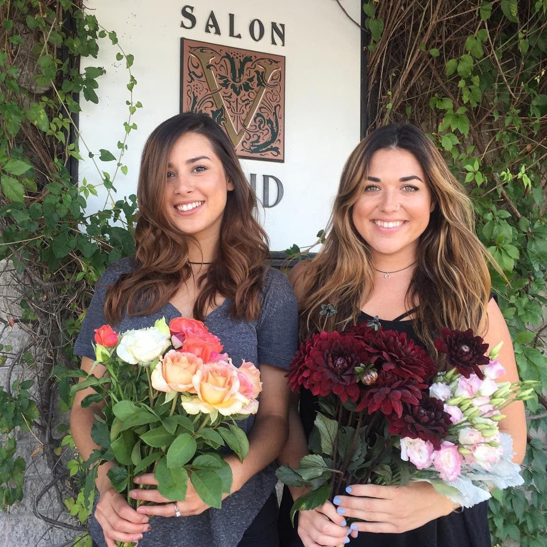2 women holding their choice of florist grade fresh organic flowers from Le Mera Gardens for their place of business in Medford Oregon.  Assorted garden roses, burgundy dahlias and soft pink lisianthus.  